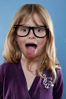 Sticking Out Tongue Prints: A young girl sticking out her tongue playfully, studio shot
