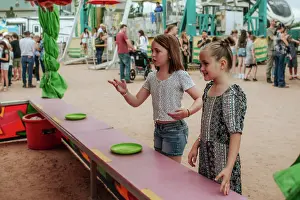 Gradeschooler Prints: Two young girls playing carnival games at county fair