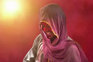 Holi Prints: Young Indian man With Colored Face Dancing During Holi Color festival