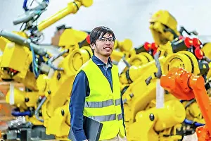Produce Prints: Young japanese engineer in charge of an automated manufacturing factory assembly line