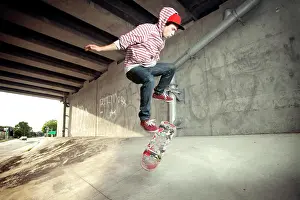 Skateboard Prints: Young male skateboarding under overpass