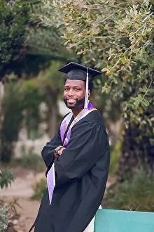 Scholar Prints: Young man with arms crossed wearing a graduation gown/cap