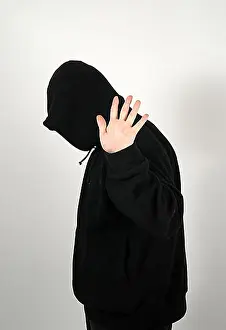Hood Prints: Young man with a black hooded shirt waving aside everything