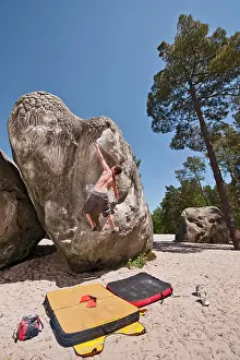 Agility Prints: young man bouldering in the forest of Fontainebleau close to Paris