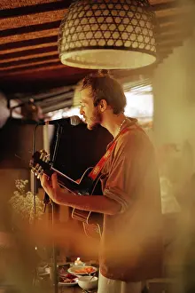 Expressive Prints: Young man musician plays the guitar and sings into a microphone