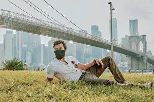 Precaution Prints: Young man sitting in park wearing face mask