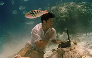 Mixed Prints: Young man sitting underwater and using a laptop
