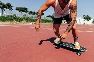 Equilibrium Prints: Young man skateboarding at basketball court during sunny day