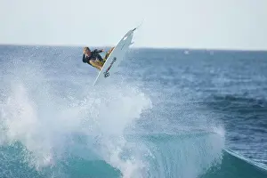 Exhilaration Prints: A young man surfing at Rocky Point, north shore
