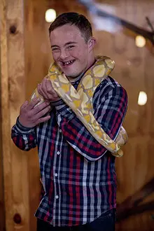 Handicapped Prints: Young man with down syndrome holding albino python snake
