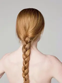 Red Hair Prints: A young naked woman with a braided ponytail, rear view