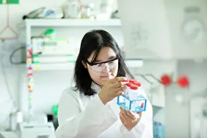 Devices Prints: young scientist female controlling a tube in a rack