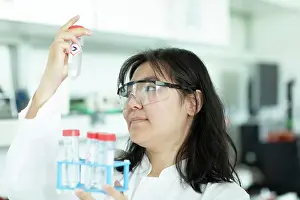 21 25 Years Old Prints: young scientist female controlling a tube of a rack