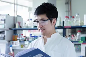 Concentrate Prints: young scientist male chinese working in laboratory
