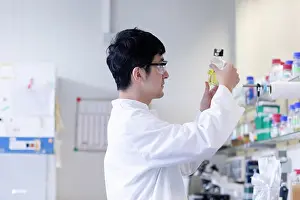 Concentrate Prints: young scientist male chinese working in laboratory