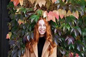 26 29 Years Old Prints: young stylish red-haired woman on the background of green leaves