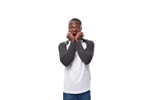 Cheerful Prints: young surprised well-groomed african man with a short haircut dressed in a sweatshirt on a studio background with copy