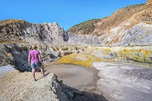 Aegean Prints: Young tourist at a crater, volcano caldera with pumice fields