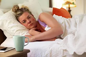 Fever Prints: Young woman in her bed debating getting out of bed