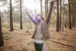 Thoughtful Prints: A young woman communing with nature in a forest in Autumn