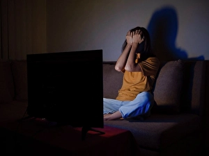 Sleepy Prints: Young woman covering face with palms watching tv at night time
