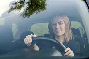 Purchase Prints: Young woman drivier Young woman driving her car on sunny day