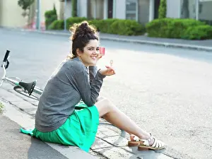 Refreshing Prints: Young woman enjoying a sunny day with a refreshing popsicle by the roadside