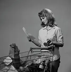 One Young Woman Only Prints: Young woman with groceries in shopping trolley