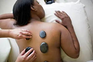 Thirty Prints: Young woman having warm stones placed on her bare back