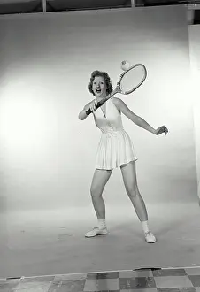 : Young woman hitting a tennis ball with a tennis racket