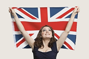 20s Adult Prints: Young woman holding British Flag with pride over gray background