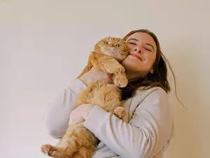Positive Emotion Prints: Young woman holds her Scottish Fold cat in a hug