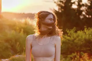 Relaxation Exercise Prints: young woman joyfully waving her hair at sunset in the middle of nature