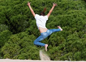 Full Length Prints: a young woman leaps over the punta paloma sand dunes, tarifa cadiz andalusia spain