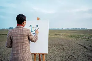 20 To 25 Years Prints: Young woman painting in front of sky