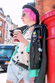 Coffee Break Prints: Young woman with pink hair and quirky style leaning against red mailbox, London, UK