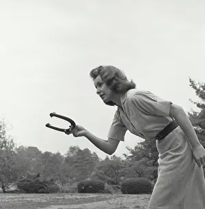 Medium Length Hair Prints: Young woman playing a game of horseshoes