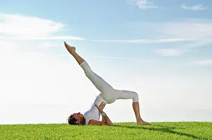 Exterior Photograph Prints: Young woman practising Hatha yoga outdoors