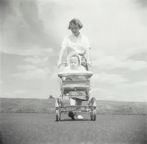 Bonnet Prints: Young woman pushing her baby in a baby stroller