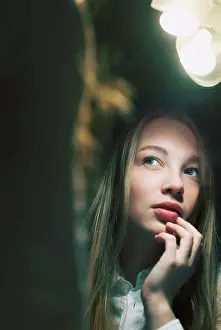Young woman reflected in mirror looking away