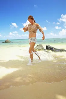 Kauai Prints: A young woman runs in the shallow water on anini beach