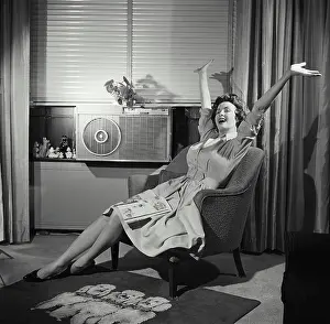 Medium Length Hair Prints: Young woman sitting in an armchair with her arms raised