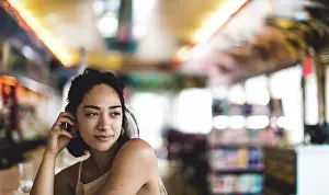 Cafe Prints: Young woman sitting at a bar counter in a diner looking over her shoulder