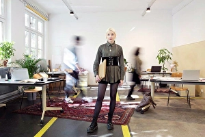 Small Group Of People Prints: Young woman standing in busy creative co-working space