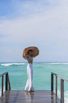 Late Twenties Prints: Young woman in a straw hat on the pier, ocean waves splashing