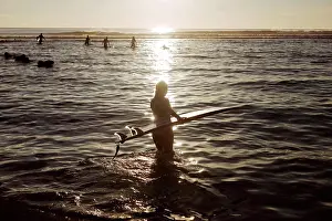 Beginnings Prints: Young woman with surfboard at the beach