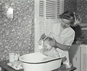 Innocence Prints: Young woman washing her son in a bathtub