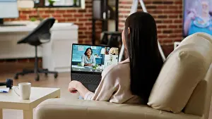 Video Prints: Young woman working remotely from home while attending virtual meeting teleconference on laptop