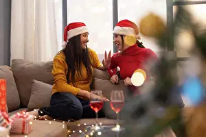 Sofa Prints: young women celebrating Christmas wine party at home
