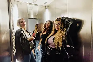 Small Group Of People Prints: Three young women in elevator
